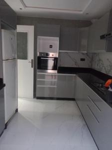 Il comprend une cuisine équipée d'une cuisinière et d'un réfrigérateur. dans l'établissement Bel app, à Agadir
