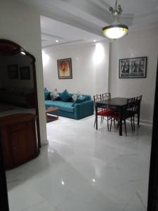 - un salon avec une table, des chaises et un canapé dans l'établissement Bel app, à Agadir