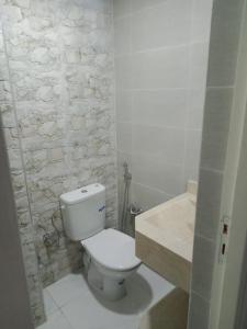 La salle de bains est pourvue de toilettes blanches et d'un lavabo. dans l'établissement Bel app, à Agadir