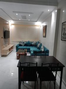 - un salon avec un canapé bleu et une table dans l'établissement Bel app, à Agadir