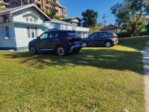 two cars parked in a yard next to a house at Gianna Homestay in Jorhāt