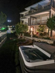un barco frente a una casa por la noche en Ivan Apartment, en Makarska
