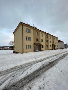 a building on a dirt road in the snow at Apartmán MD in Žacléř