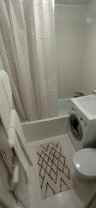 a bathroom with a shower curtain and a toilet at Park Apartments in Dnipro