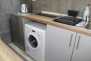 a kitchen with a washing machine and a sink at Апартаменты Пластира in Athens