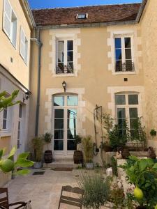 une maison avec une porte et quelques plantes dans l'établissement Maison des Pilastres au cœur d'Auxerre, à Auxerre