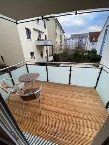 a wooden deck with a table and a chair on a balcony at 3-Zimmer Wohnung mit Top Lage in Gießen