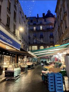 a city street with a market in front of a building at New Apartment near Champs Elysées in Paris