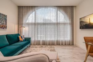 un soggiorno con un divano verde e una grande finestra di Castle Buildings a Belfast