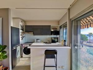 a kitchen with a counter and a bar with a stool at Résidence Tiercé in Cagnes-sur-Mer