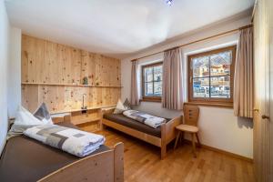 a bedroom with a bed and a couch at Kalchgruberhof Wohnung Alpenrose in Ultimo