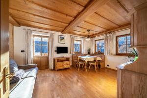 ein Wohnzimmer mit Holzdecken und einem Tisch in der Unterkunft Kalchgruberhof Wohnung Alpenrose in Ulten