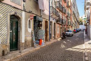 an alley with a car parked on the side of a street at ALTIDO Chic 2BR Apt in Bairro Alto, 2mins to São Pedro de Alcântara viewpoint in Lisbon