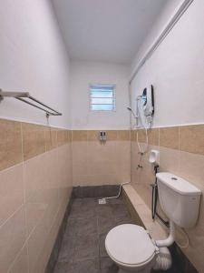 uma pequena casa de banho com WC e chuveiro em Lovely & Cozy Apt In Nature City em Sandakan