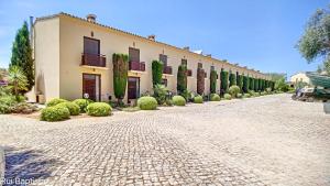 a large building on a cobblestone street at Arrancada 14 in Pêra
