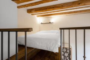 a bedroom with a bed with white sheets and wooden ceilings at Old Port Riverside Apartments in City Center in Belgrade