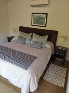 a bedroom with a large bed with two pillows at Casa de Huéspedes Villa Pehuenia in Villa Pehuenia