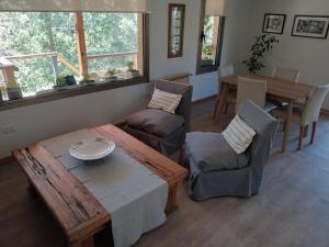 - un salon avec une table et des chaises en bois dans l'établissement Casa de Huéspedes Villa Pehuenia, à Villa Pehuenia