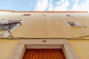 a facade of a building with a wooden door at Good Vibes Apartment in Setúbal