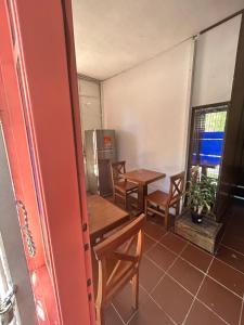 a room with two tables and chairs and a refrigerator at Hostel Parece Mentira in Colonia del Sacramento