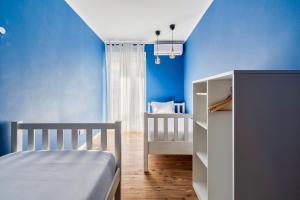 a bedroom with blue walls and a bed and a crib at Wonder Blue in Setúbal