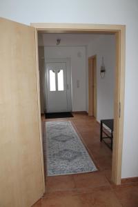 einen leeren Flur mit Tür und Teppich in der Unterkunft Ferienwohnung in Ruppichteroth Winterscheid in Ruppichteroth