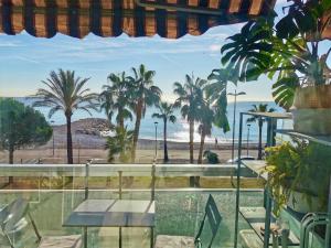 a room with a view of the beach and palm trees at Résidence Tiercé in Cagnes-sur-Mer