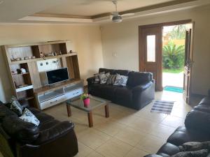 sala de estar con 2 sofás y TV en Casa de frente pro mar em Arraial do Cabo, en Arraial do Cabo