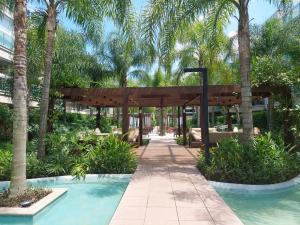 um pavilhão com palmeiras e uma piscina em Barra Garden Happy - Condomínio Barra Village Lakes tipo Resort - Recreio dos Bandeirantes no Rio de Janeiro