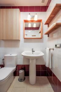 La salle de bains est pourvue d'un lavabo blanc et de toilettes. dans l'établissement Amazing studio in the old city, à Séville