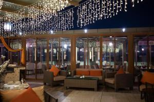 a restaurant with chandeliers and tables and chairs at Frontel Jeddah Hotel Altahlia in Jeddah