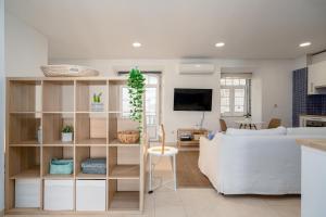 a living room with a white couch and a table at Setúbal Downtown Blue in Setúbal