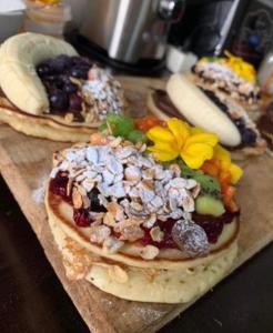 three pancakes with fruit and nuts on a cutting board at Bright Apartment Close to the Beach & City Center in Praia