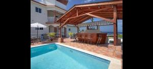 a swimming pool in front of a house at Hills Royale Villa -Ironshore Montego Bay in Montego Bay