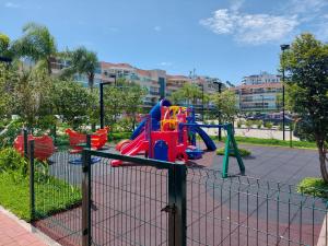 a playground with a slide in a park at Barra Garden Happy - Condomínio Barra Village Lakes tipo Resort - Recreio dos Bandeirantes in Rio de Janeiro