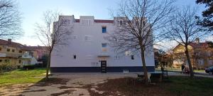 a large white building with trees in front of it at Smokva in Zadar