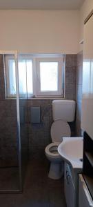 a bathroom with a toilet and a sink and a window at Smokva in Zadar