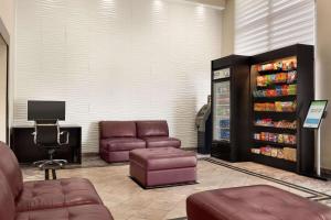 uma sala de espera com sofás e uma máquina de refrigerantes em Days Inn & Suites by Wyndham Anaheim At Disneyland Park em Anaheim