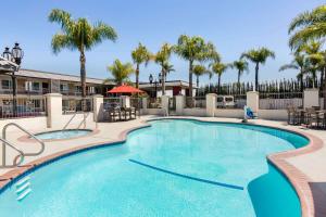 una gran piscina con palmeras en el fondo en Days Inn & Suites by Wyndham Anaheim At Disneyland Park en Anaheim