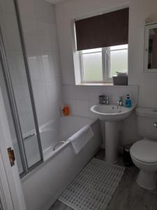 a bathroom with a tub and a sink and a toilet at Comfort, peace and quiet guaranteed in this 3 bed in West Auckland