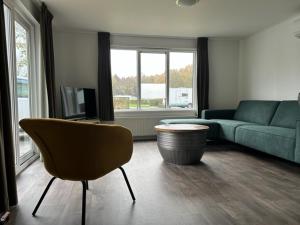 Chalet Eikenallee في Nijensleek: غرفة معيشة مع أريكة وكرسي