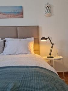 una camera da letto con un letto con una lampada su un tavolo di Timi's House - Espaçoso apartamento a 350 m da praia e centro da cidade velha ad Albufeira