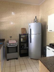 a kitchen with a stainless steel refrigerator and a stove at Casa em frente à praia Boracéia in Boracéia