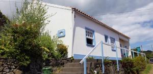 a white house with stairs in front of it at A Barraka: rent your room in Flores! in Lajes das Flores