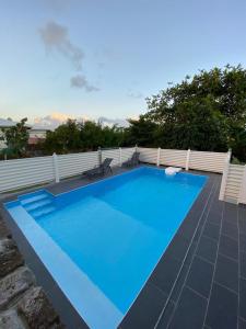 une grande piscine bleue sur une terrasse dans l'établissement Villa La roche, à Le Moule