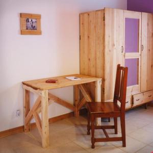 a wooden desk with a chair and a cabinet at A Barraka: rent your room in Flores! in Lajes das Flores