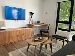 een woonkamer met een tv en een tafel en stoelen bij Residencias San Lorenzo in Mar del Plata +10 foto's