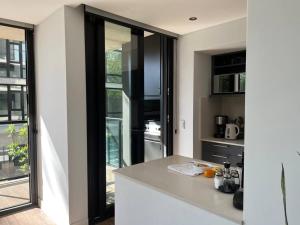 een keuken met een wit aanrechtblad en glazen deuren bij Residencias San Lorenzo in Mar del Plata