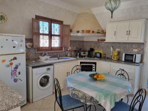 a kitchen with a table with a bowl of fruit on it at Dar Eva in Aghīr