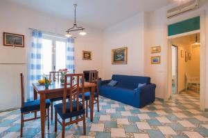 een woonkamer met een tafel en een blauwe bank bij Marina Grande,102 - Blue Horizon Sorrento in Sorrento
